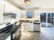 Well-lit kitchen with stainless steel appliances, white cabinets, and a view of the deck at 1125 Field Meadows Dr, Zebulon, NC 27597