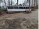 Single-story home with a long, screened-in porch and neutral exterior, surrounded by trees at 122 Tomahawk Dr, Louisburg, NC 27549