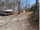 Exterior view of the home and surrounding sheds, with a peaceful environment, surrounded by trees at 122 Tomahawk Dr, Louisburg, NC 27549