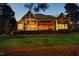 Expansive backyard with lush lawn and elegant screened-in porch at dusk at 12417 Richmond Run Dr, Raleigh, NC 27614