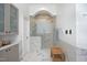 Bright bathroom with marble floors, glass-enclosed shower, and gray cabinets at 12417 Richmond Run Dr, Raleigh, NC 27614
