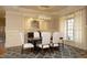 Charming dining room with elegant chandelier, stylish table with white chairs, and wainscoting at 12417 Richmond Run Dr, Raleigh, NC 27614