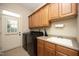 Functional laundry room with washer, dryer, cabinetry, utility sink and door to exterior at 12417 Richmond Run Dr, Raleigh, NC 27614