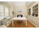 Bright office space featuring a built-in bookcase, fireplace, and large windows that provide plenty of natural light at 12417 Richmond Run Dr, Raleigh, NC 27614