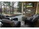 Covered patio features stone fireplace, outdoor seating, and scenic backyard views at 12417 Richmond Run Dr, Raleigh, NC 27614