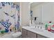 Cozy bathroom features colorful shower curtain, a gray vanity with a large mirror, and ample counter space at 133 Alumroot Road Rd, Holly Springs, NC 27540