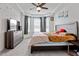 Comfortable bedroom with a ceiling fan, carpet, large windows and a dresser with a TV at 133 Alumroot Road Rd, Holly Springs, NC 27540