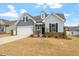 Inviting home featuring a two-car garage, brick accents, and well-maintained front yard at 133 Alumroot Road Rd, Holly Springs, NC 27540