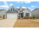 Attractive home featuring a two-car garage, brick accents, and inviting curb appeal at 133 Alumroot Road Rd, Holly Springs, NC 27540