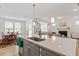 Modern kitchen with a large island, stainless steel sink, and open layout to living spaces at 133 Alumroot Road Rd, Holly Springs, NC 27540