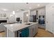 Modern kitchen featuring an island with quartz countertops, gray cabinets and stainless steel appliances at 133 Alumroot Road Rd, Holly Springs, NC 27540