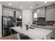 Modern kitchen featuring stainless steel appliances, a large island, and stylish gray cabinets at 133 Alumroot Road Rd, Holly Springs, NC 27540