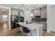 Modern kitchen featuring stainless steel appliances, a large island, and stylish gray cabinets at 133 Alumroot Road Rd, Holly Springs, NC 27540