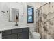 Modern bathroom with a dark vanity cabinet, stylish shower curtain, and a tiled backsplash at 1354 Briar Chapel Pkwy, Chapel Hill, NC 27516
