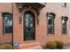 Close-up of an arched front door, brick facade, and manicured landscaping, highlighting the home's architectural details at 1354 Briar Chapel Pkwy, Chapel Hill, NC 27516