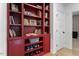 Stylish hallway featuring red built-in bookcase, white trim, and a view to another room at 1354 Briar Chapel Pkwy, Chapel Hill, NC 27516