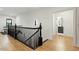 Hallway with hardwood floors, decorative banister, and an open doorway to a bathroom at 1354 Briar Chapel Pkwy, Chapel Hill, NC 27516