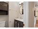 Well-lit half bathroom featuring a modern vanity, mirror, and built-in storage at 136 Dixie Ln, Youngsville, NC 27596