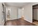 Neutral bedroom with wood-look floors leading to a bathroom and closet space at 136 Dixie Ln, Youngsville, NC 27596