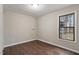 Neutral bedroom with wood-look floors, a large window, and baseboard trim at 136 Dixie Ln, Youngsville, NC 27596