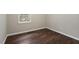 Empty bedroom featuring wood-look floors, and a view of the window at 136 Dixie Ln, Youngsville, NC 27596