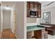 Hallway leading to breakfast nook featuring custom cabinetry, a microwave, and natural light at 136 Dixie Ln, Youngsville, NC 27596