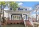 Charming two-story home featuring a welcoming front porch, brick columns, stairs and manicured front yard at 1608 Scales St, Raleigh, NC 27608