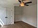 Cozy bedroom featuring a ceiling fan, built-in shelves, and hardwood floors at 2112 Hamrick Dr, Raleigh, NC 27615