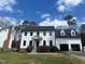 Charming two-story home featuring a clean white facade, dark trim, and inviting front entrance with a well manicured lawn at 2112 Hamrick Dr, Raleigh, NC 27615