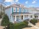 Attractive two-story blue home with a inviting front porch, columns, and manicured landscaping at 2118 Cloud Cover Ln, Raleigh, NC 27614