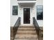 Elegant entryway with brick steps, black metal railings, and a dark wood front door at 2214 Woodrow St, Durham, NC 27705