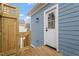 Side entry door of a blue home with a small deck and wooden privacy screen at 2218 Woodrow St, Durham, NC 27705