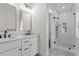 Modern bathroom with dual sinks, marble countertops, sleek black fixtures, and a glass-enclosed shower at 2218 Woodrow St, Durham, NC 27705