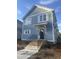 Charming two-story home featuring light blue siding, white trim, and a welcoming front entrance with brick steps at 2218 Woodrow St, Durham, NC 27705