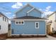 Two-story home featuring blue siding, a dark roof, nice landscaping and a concrete parking area at 2218 Woodrow St, Durham, NC 27705