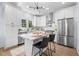 Modern kitchen featuring white cabinets, stainless steel appliances, marble countertops, and island with seating at 2218 Woodrow St, Durham, NC 27705