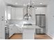 Modern kitchen featuring white cabinets, stainless appliances, and a stylish island with a marble countertop at 2218 Woodrow St, Durham, NC 27705