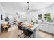 Spacious kitchen seamlessly connected to the living area with stainless appliances, modern light fixture and white cabinets at 2218 Woodrow St, Durham, NC 27705