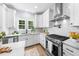 Modern kitchen with stainless steel appliances, white marble countertops, and white cabinets at 2218 Woodrow St, Durham, NC 27705