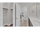 A bathroom with brown cabinets, white countertop, closet, and towel rack at 2220 Stillness Pond Ln, Apex, NC 27539