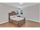 A bedroom with a wooden bed frame, hardwood floors, and two windows that provide natural light at 2220 Stillness Pond Ln, Apex, NC 27539