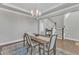 Elegant dining room featuring hardwood floors, a stylish chandelier, and staircase at 2220 Stillness Pond Ln, Apex, NC 27539