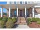 Inviting front porch with brick stairs, decorative railing, and space for seating at 2220 Stillness Pond Ln, Apex, NC 27539