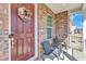 Inviting front porch with seating, featuring brick accents and a decorative wreath at 2220 Stillness Pond Ln, Apex, NC 27539