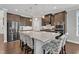 Kitchen island with granite counters, stainless appliances, brown cabinets and island seating at 2220 Stillness Pond Ln, Apex, NC 27539