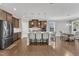 Open kitchen with granite counters, stainless appliances, brown cabinets and island seating at 2220 Stillness Pond Ln, Apex, NC 27539