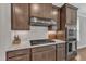 Kitchen with granite counters, stainless appliances, brown cabinets and stainless range hood at 2220 Stillness Pond Ln, Apex, NC 27539