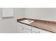 Laundry room sink with brown countertop and white cabinets at 2220 Stillness Pond Ln, Apex, NC 27539