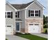 Charming two-story home with gray siding, stone accents, a blue front door, and white garage doors at 225 Elyse Overlook Loop, Sanford, NC 27332