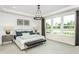 Bright bedroom with large windows, tray ceiling, stylish lighting, and a comfortable upholstered bench at 2404 Del Webb Gardens Dr, Fuquay Varina, NC 27526